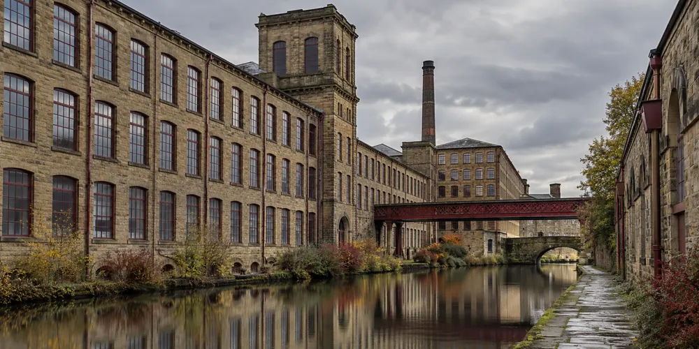 Stone mill buildings alongside a canal, reflecting the Bradford district’s industrial heritage